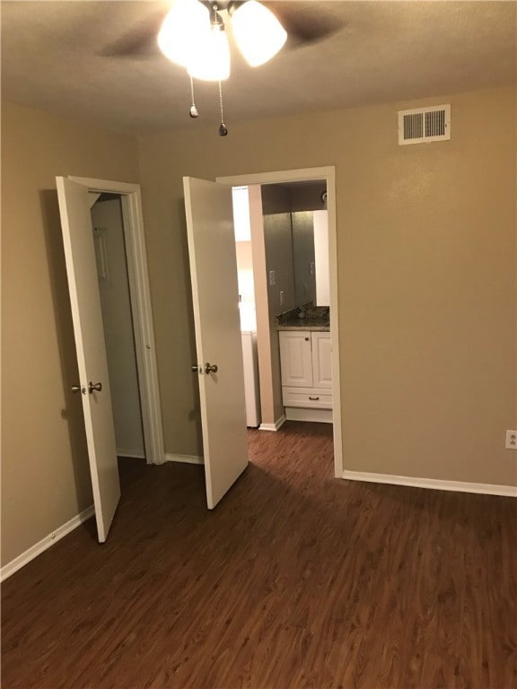 Empty room with a ceiling fan, dark wood-style flo