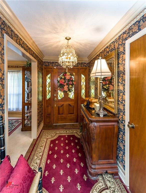 Entry has detailed crown molding, dainty chandelie