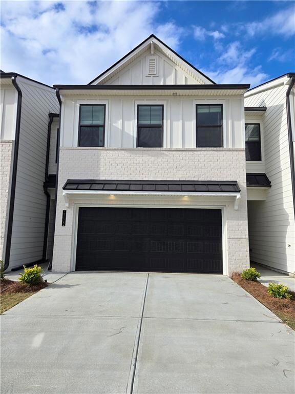 View of front facade featuring an attached garage, brick siding, and driveway