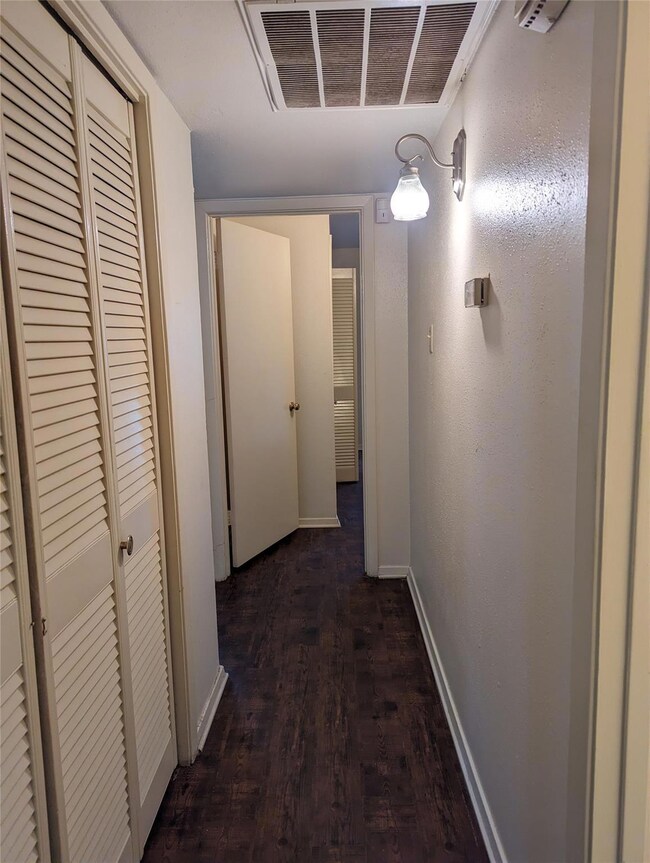 Hall with dark hardwood / wood-style flooring