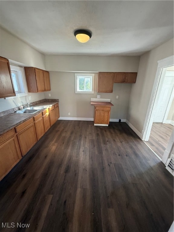 Kitchen featuring brown cabinetry and dark wood finished floors