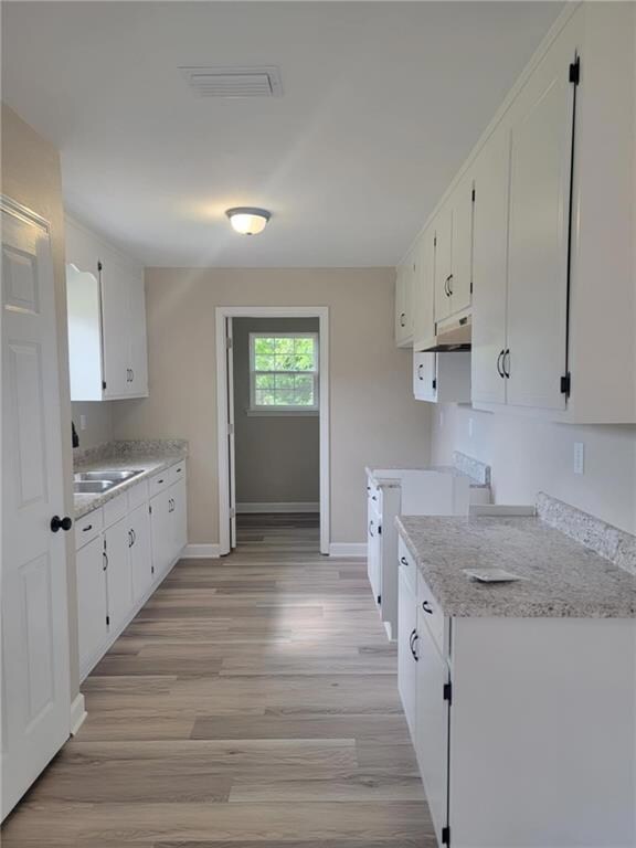 Unfurnished living room with ceiling fan, vaulted ceiling, wood finished floors, and baseboards