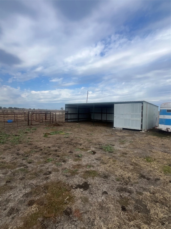 View of yard featuring an outbuilding, an outdoor structure, and a rural view
