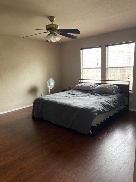 Bedroom with baseboards, ceiling fan, and wood finished floors
