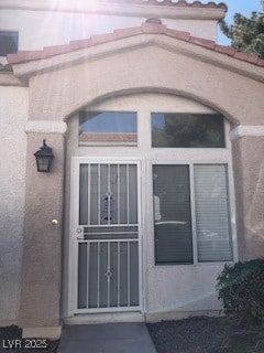 View of exterior entry with stucco siding