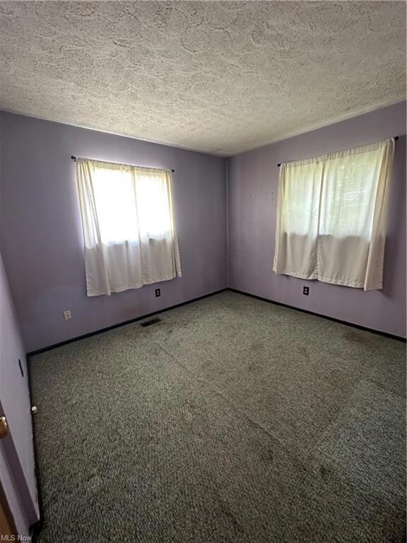 Carpeted bedroom with a textured ceiling