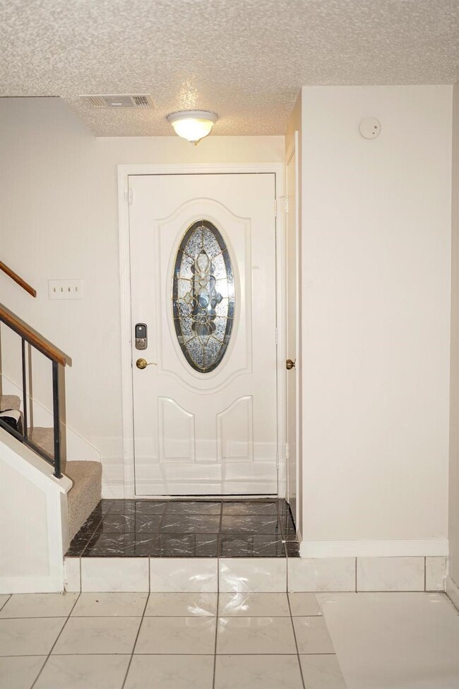 Entryway featuring stairs, a textured ceiling, and