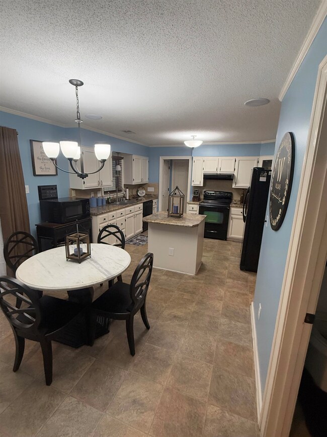 Dining space with crown molding, a notable chandel