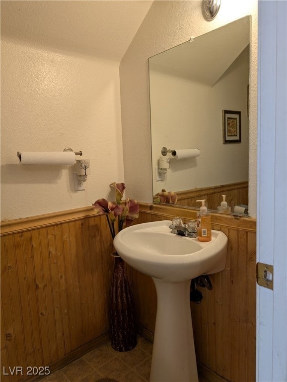 Bathroom with wood walls, tile patterned flooring,