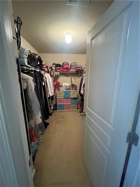 Spacious closet with carpet floors and visible ven