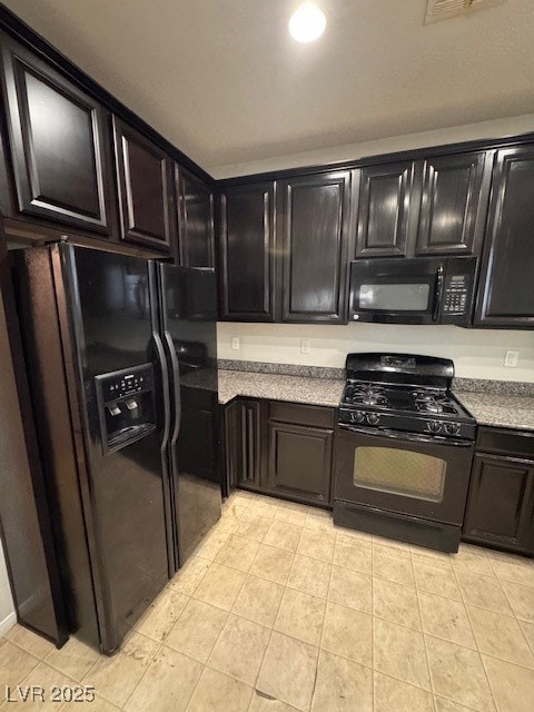 Kitchen featuring stove, fridge, light tile patter