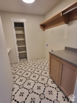 Washroom featuring washer hookup, cabinet space, and light floors