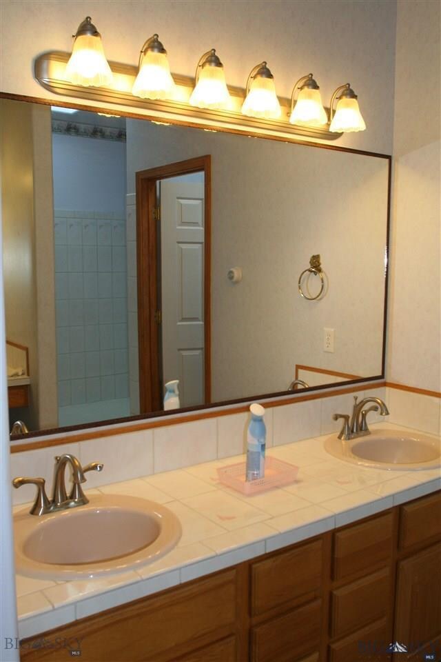 Spacious master bath with matching sinks and natur