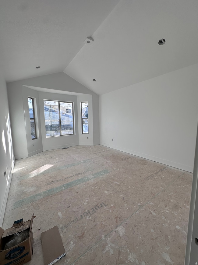 Unfurnished room featuring lofted ceiling