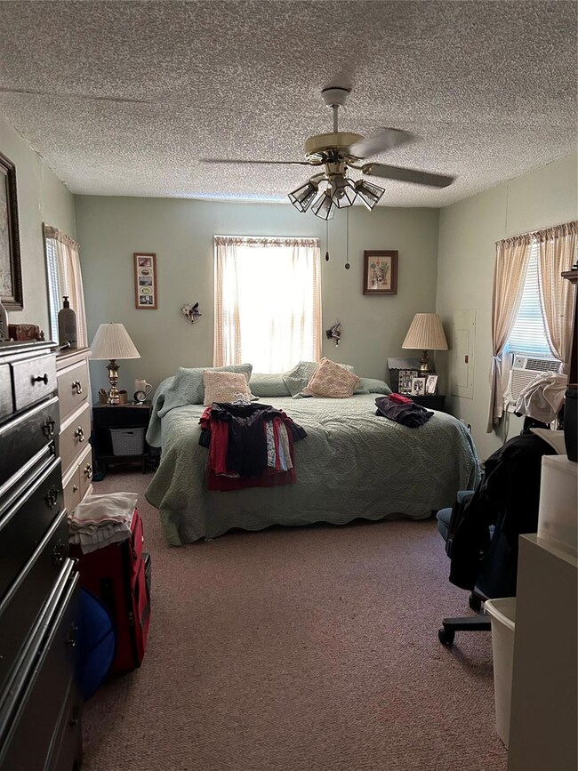 Bedroom with carpet floors, a textured ceiling, an
