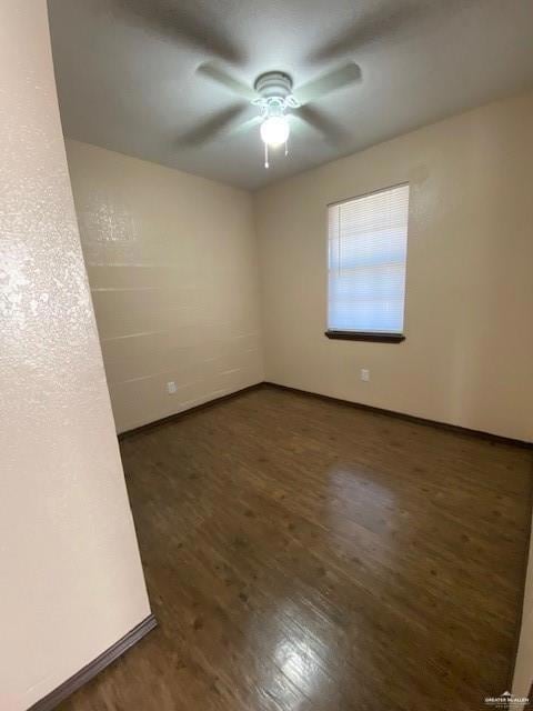 Unfurnished room featuring ceiling fan and dark hardwood / wood-style flooring