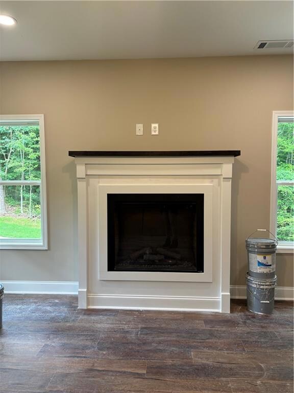 Detailed view of wood finished floors and a fireplace