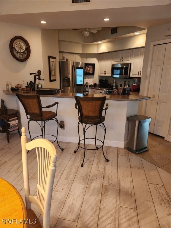 Kitchen featuring refrigerator, dark countertops,