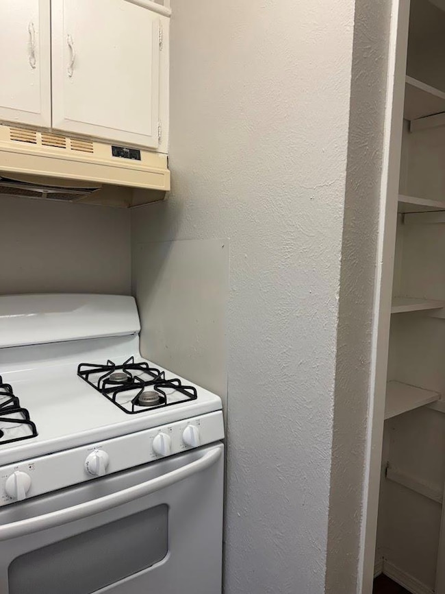 Kitchen with white range with gas cooktop, under 