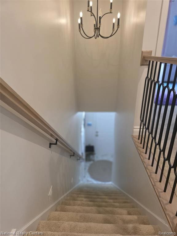 Stairs with a chandelier and baseboards