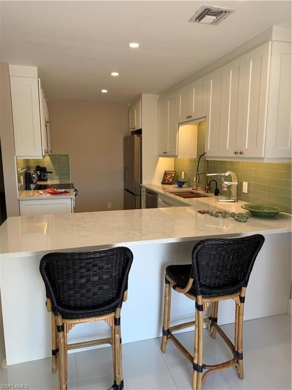 Kitchen with refrigerator, sink, a breakfast bar a