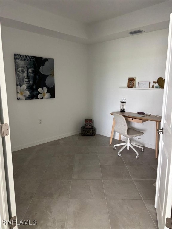 Home office with light tile patterned floors and baseboards