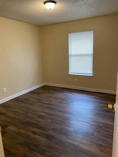 Empty room featuring baseboards, a textured ceili
