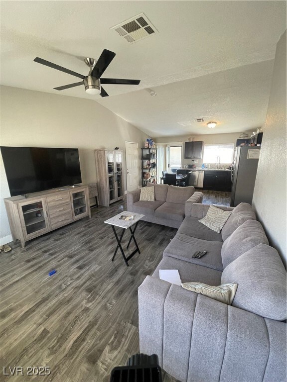 Living room with ceiling fan, vaulted ceiling, vis