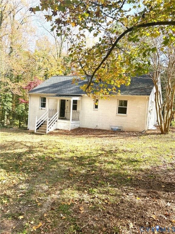 Rear view of house featuring roof with shingles and covered porch