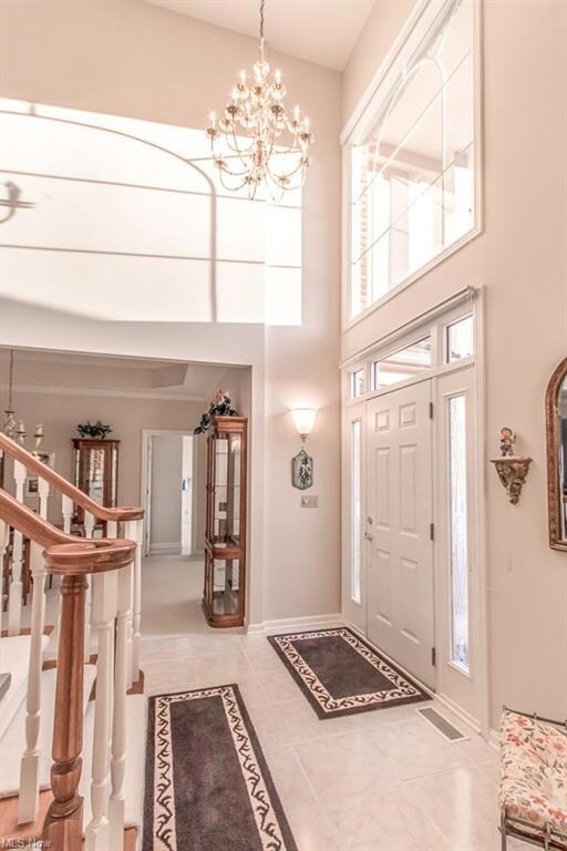 Bright foyer with dramatic staircase, chandelier t