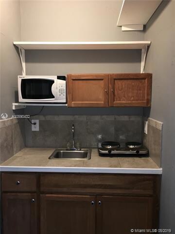 The kitchen features a microwave oven and two burner stove,