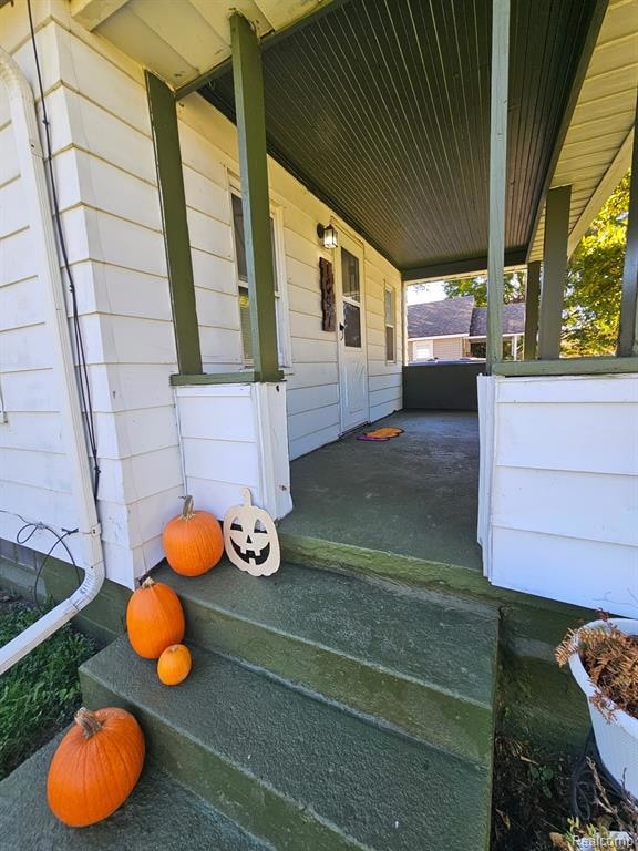 Doorway to property featuring covered porch