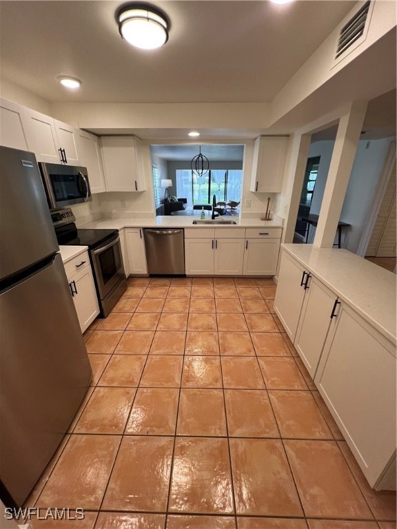 Kitchen with dishwasher, white cabinets, range, an