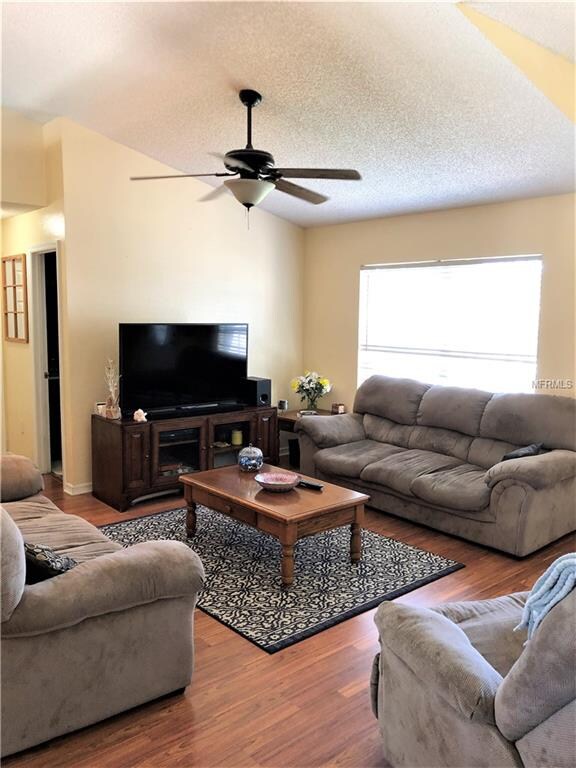 Living room with vaulted ceilings, ceiling fan and