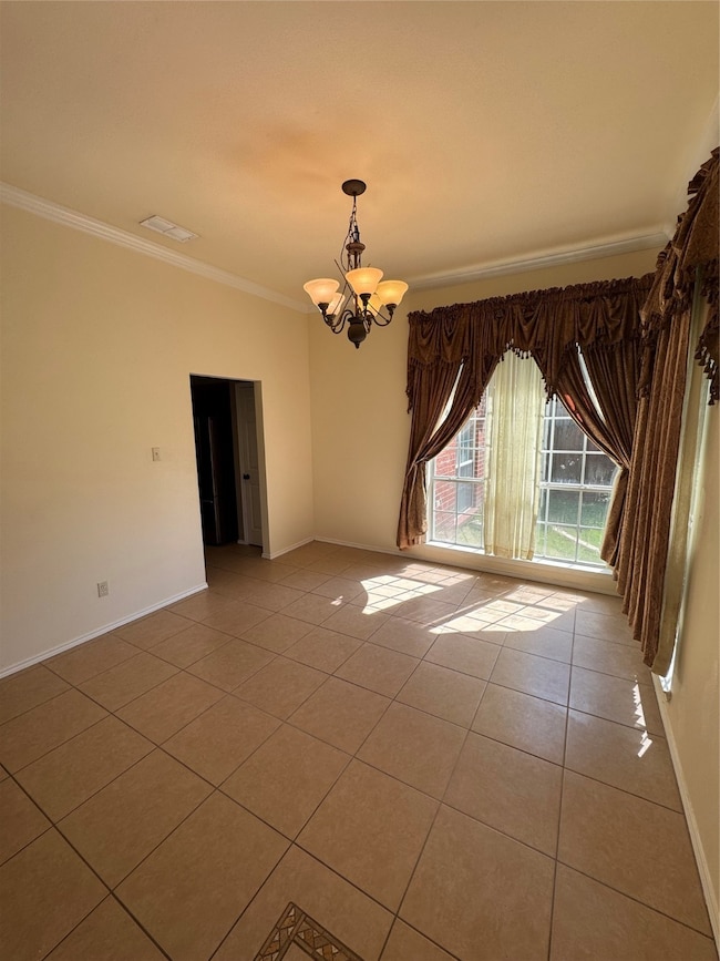 Tiled empty room with a chandelier and crown molding
