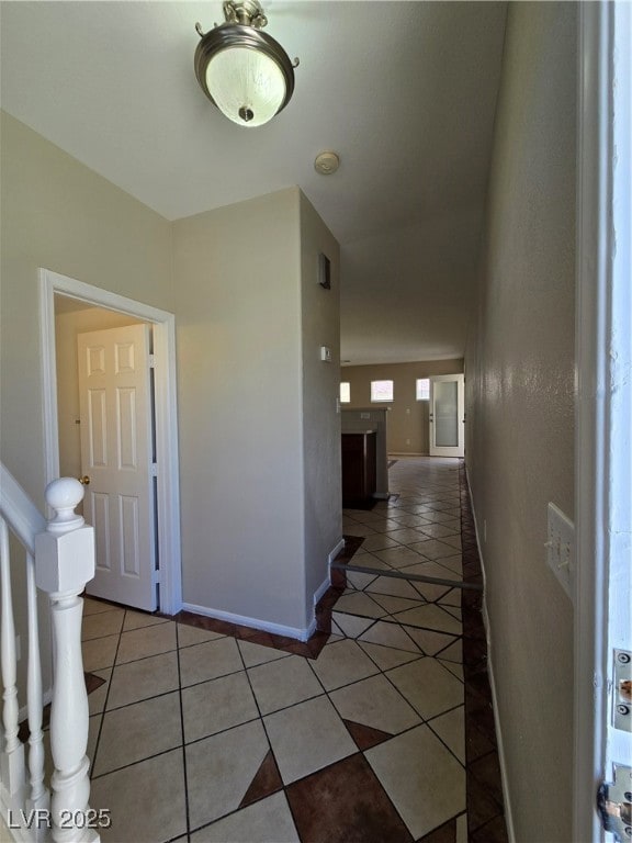 Hall with light tile patterned floors and stairway