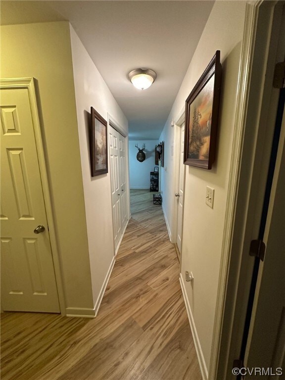 Hall with light hardwood / wood-style floors