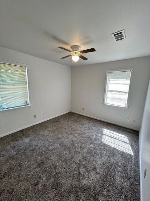 Carpeted empty room featuring ceiling fan
