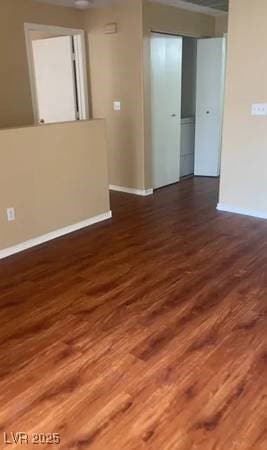 Spare room featuring dark wood-style flooring