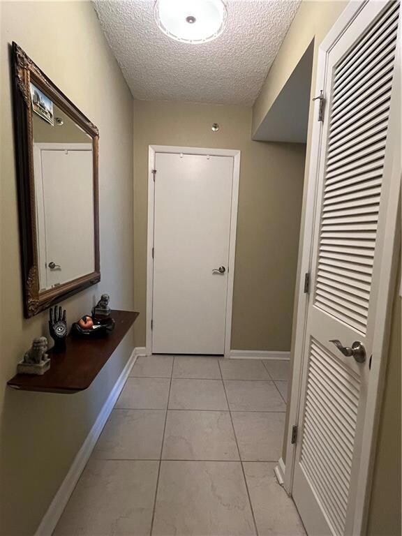 Doorway with light tile patterned floors and a tex