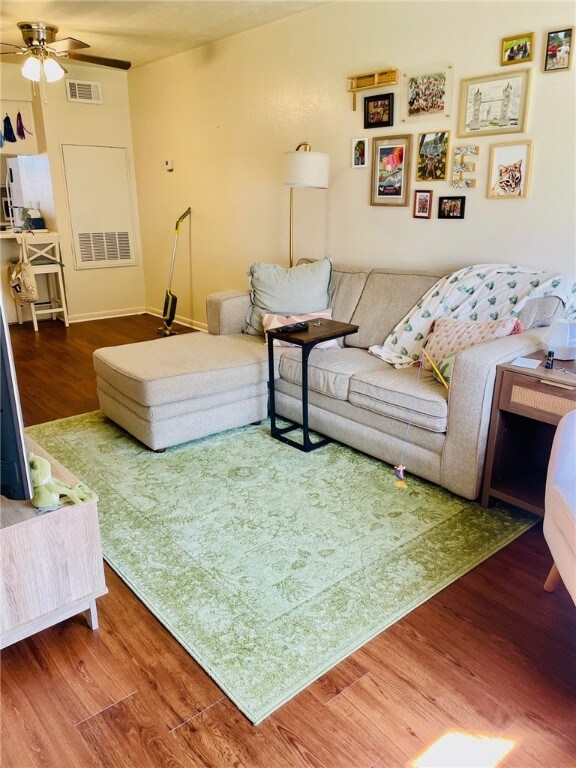 Living area with a ceiling fan, wood finished floo