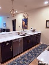 Bar with light countertops, recessed lighting, decorative light fixtures, stainless steel dishwasher, and a chandelier