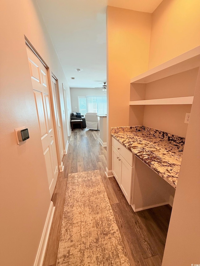 Corridor with light wood-style floors and baseboards