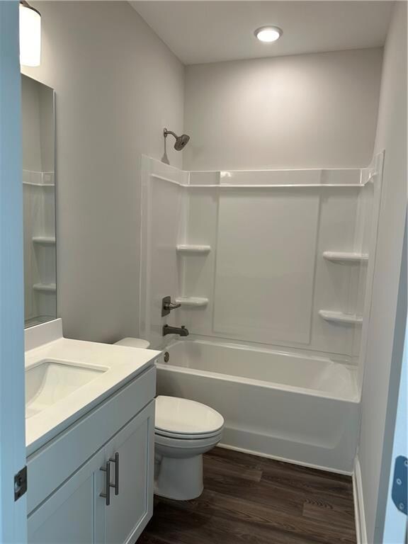 Full bathroom with toilet, hardwood / wood-style f