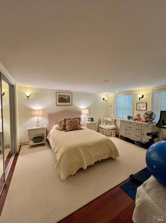 One lower level bedroom of the main home with large closet and wood floors.