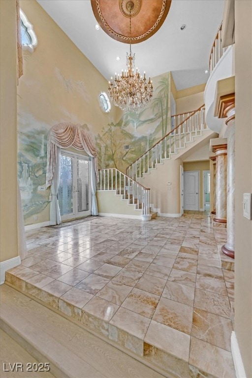 Entrance foyer featuring stairway, a chandelier, a towering ceiling, recessed lighting, and french doors