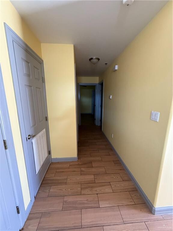 Corridor featuring wood finish floors and baseboards
