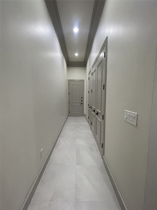 Hall with ornamental molding and recessed lighting