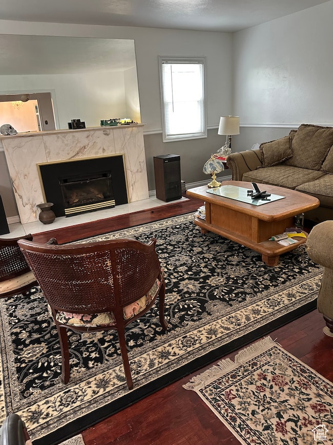 Living room with dark wood-type flooring and a fireplace