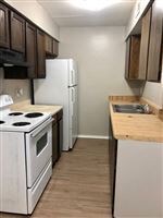 Kitchen featuring white appliances, dark brown cab
